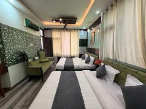 a hotel room with two beds and a couch at Pacific Grand in Amritsar