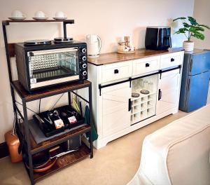 a microwave oven on a stand in a kitchen at Klein Geluk Cottage in Stellenbosch