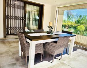 a dining room table with chairs and a window at Klein Geluk Cottage in Stellenbosch