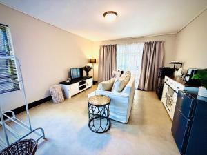 a living room with a couch and a table at Klein Geluk Cottage in Stellenbosch +5 photos