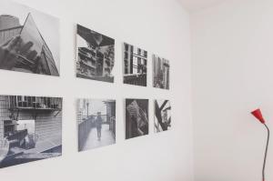 Eine Reihe von Fotografien hängt an einer weißen Wand in der Unterkunft TRACES Lagos in Lagos