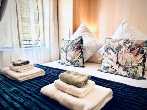 a hotel room with towels and pillows on a bed at Klein Geluk Cottage in Stellenbosch