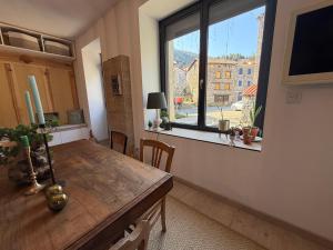 a dining room with a table and a large window at L'Etape des Jacquets - Monistrol d'allier in Monistrol-dʼAllier