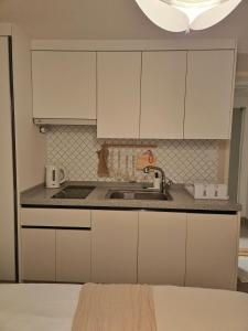 a kitchen with white cabinets and a sink at The YoGwan in Suwon