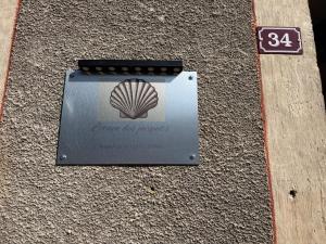 a sign with a shell on the side of a building at L'Etape des Jacquets - Monistrol d'allier in Monistrol-dʼAllier