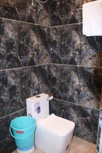a bathroom with a toilet and a bucket at Red Leaf Hotel in Māler Kotla