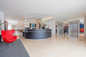 a lobby with a bar and a red chair at Edifício Curitiba João Bettega in Curitiba