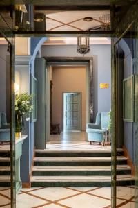 a hallway with blue walls and stairs with a blue couch at Hotel Marisa in Rome