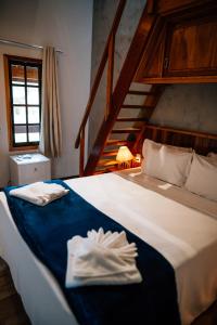 a bedroom with a bed with two towels on it at Espaço Villa Verde in Ibiúna +98 photos