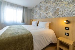 a bedroom with a large bed and a window at The Originals City Hôtel-Restaurant-Terrasse du PAarc Gravelines Dunkerque in Gravelines +28 photos
