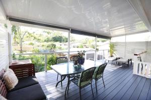 a screened in porch with a table and chairs at Enchanted Garden, 3 bedrooms in Sandstone Point