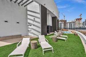 a group of lounge chairs on the roof of a building at Beautiful Miami Apt Pool & Beach for 3 Guests in Miami