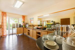 a large kitchen with a table with plates on it at acora Bonn Living the City in Bonn