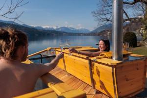 two people sitting in a boat with wine glasses at Villa Postillion am See in Millstatt