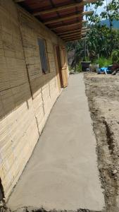 a concrete sidewalk next to a building with a door at Finca Hostal Eva Maria in Santa Marta