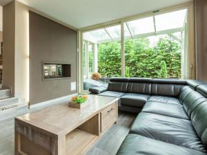 a living room with a leather couch and a table at Luxury Villa with Sauna and bubble bath in Middelkerke