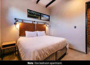 a bedroom with a bed and a window at Menlyn Lofts in Pretoria