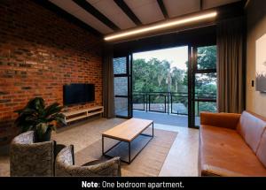 a living room with a brick wall and a television at Menlyn Lofts in Pretoria
