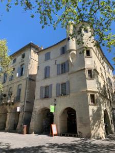 a large stone building with a sign in front of it at In Situ B&B in Uzès