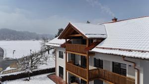 a building with snow on the roof at Gipfelblick Weißenbacher in Übersee