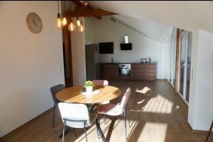 a dining room with a wooden table and chairs at Gipfelblick Weißenbacher in Übersee