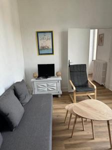 a living room with a couch and a table at Appartement 16 Colette in La Bourboule