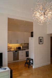 a kitchen with white cabinets and a chandelier at Executive Living Södermalm Chic in Stockholm
