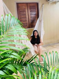 a woman sitting in a hammock in a house at Casa em Praia de Flecheiras in Trairi