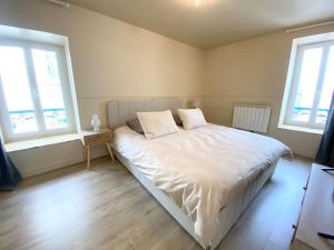 a bedroom with a white bed with two pillows on it at Le Cocon du Büech in Veynes