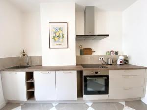 a kitchen with white cabinets and a counter top at Le Cocon du Büech in Veynes +14 photos