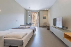 a bedroom with a large bed and a flat screen tv at Torrearsa street 35 in Trapani