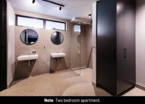 a bathroom with two sinks and two mirrors at Menlyn Lofts in Pretoria +52 photos