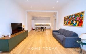 a living room with a blue couch and a tv at HT - Basilica View Luxury Loft in Padova