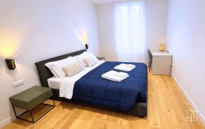 a bedroom with a bed with a blue blanket on it at HT - Basilica View Luxury Loft in Padova