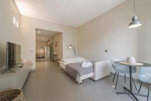a bedroom with a bed and a table and a tv at Torrearsa street 35 in Trapani