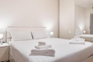 a white bedroom with towels on a bed at Gerusalemme's Nest - In the heart of the city in Milan
