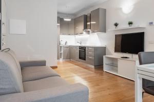 a living room with a couch and a flat screen tv at Gerusalemme's Nest - In the heart of the city in Milan