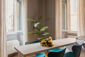 a dining room with a table and chairs and a palm tree at Campo de Fiori Bright Apartment in Rome