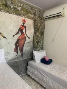 a room with a painting of a woman on the wall at Suite Africana Aracaju in Aracaju