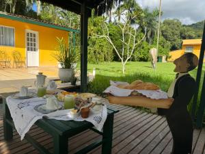 a table with a tray of food on a deck at Sítio Mais Lindo do Mundo in Ilha de Guaratiba