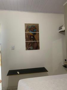 a white wall with a picture of a child at Suite Africana Aracaju in Aracaju