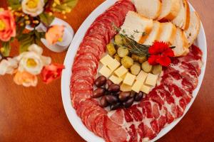 a plate of food with meat and cheese and beans at Hotel Villa Michelon in Bento Gonçalves