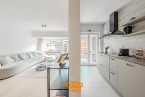 a kitchen and living room with a couch and a table at Velasquez 0303 in Nieuwpoort +15 photos