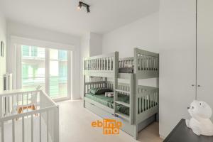a white room with a crib and a bunk bed at Velasquez 0303 in Nieuwpoort