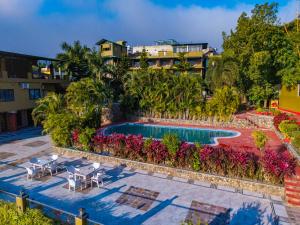 an aerial view of a resort pool with chairs and flowers at Flying Sparrow Riverside Resort in Dhikuli