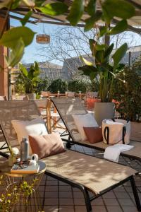 an outdoor patio with chairs and tables and plants at Hotel Marisa in Rome