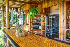 a wooden table with a bowl of fruit on a porch at Casas D'Água Doce - Casa Amora in Ilhabela