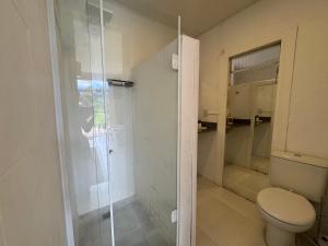 a bathroom with a toilet and a glass shower at Sítio Mais Lindo do Mundo in Ilha de Guaratiba +35 photos
