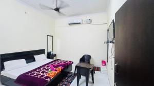 a bedroom with a bed and a black chair at Hotel Orchha Inn in Orchha