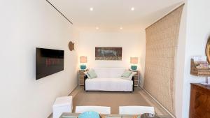 a living room with a white couch and a tv at Casa Elisabeth in Portovenere